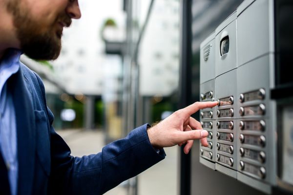 Moderne Türsprechanlage mit Video- und Audiofunktion an einem Gebäudeeingang, Bedienung über Klingeltasten für sichere Zutrittskontrolle und Gebäudekommunikation.